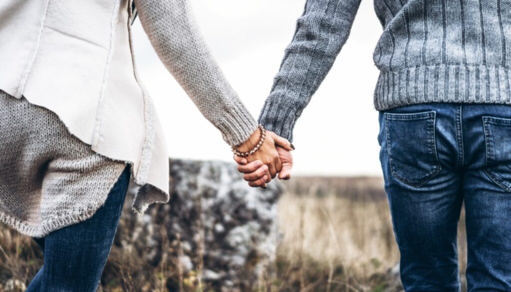 Photo of romatic couple hands, walking outdoor and spending time together.